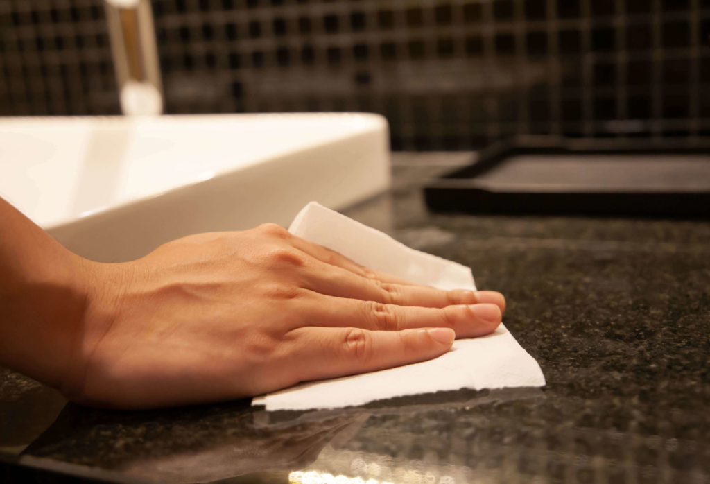 Hand wiping countertop with paper towel
