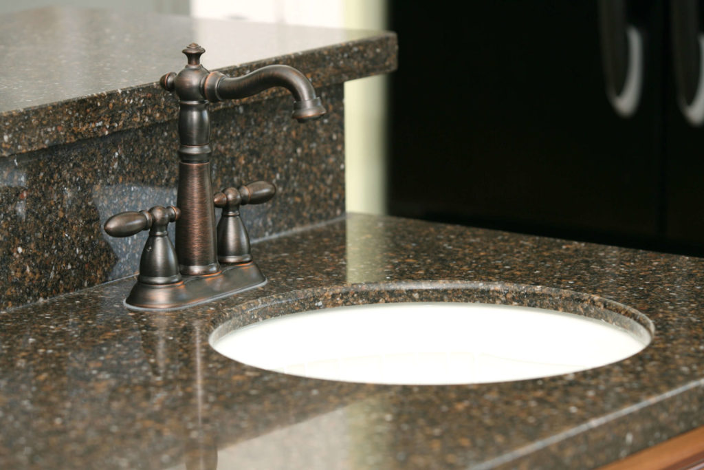 Dark quartz countertop with bronze tap
