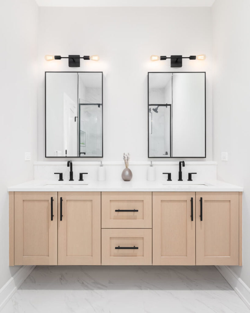 A white bathroom with double sinks and matching mirrors above each sink