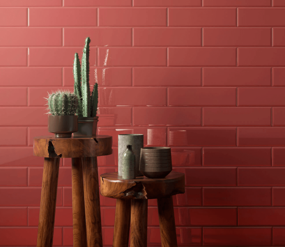 A photo of a wall with red tile and red grout. There are two wooden stools with plants and ceramic pots in front of the wall. (Image source: Midgley West).